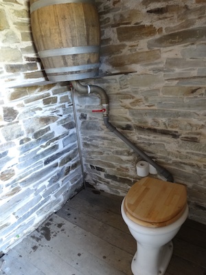 Outhouse toilet featuring a composting flush toilet