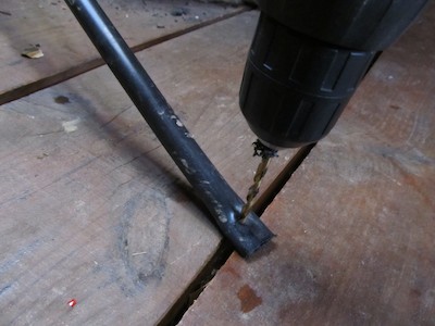 Drilling crimped pipe end. At last a practical use for the large gaps between the yurt floorboards (caused by shrinkage of green timber)!